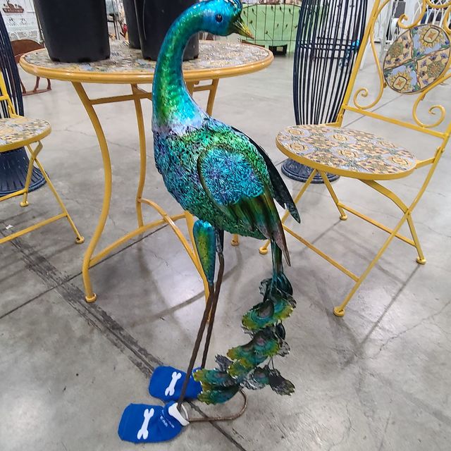 A metal peacock sculpture in blue socks