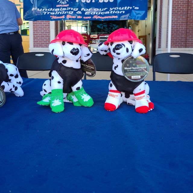 Two stuffed Dalmatians in fire hats wearing socks