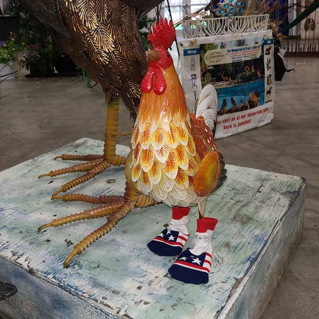 A rooster sculpture wearing flag socks
